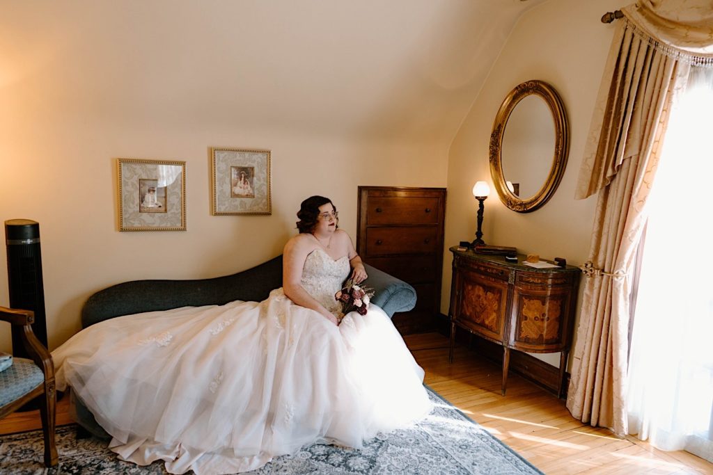 A bride sitting in her wedding dress in the dressing room at the Redfield Estates.