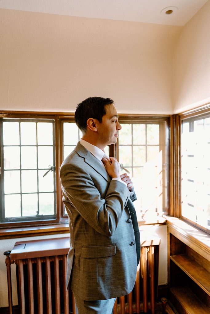 A groom getting ready in the getting ready space of the Grove Redfield Estate.