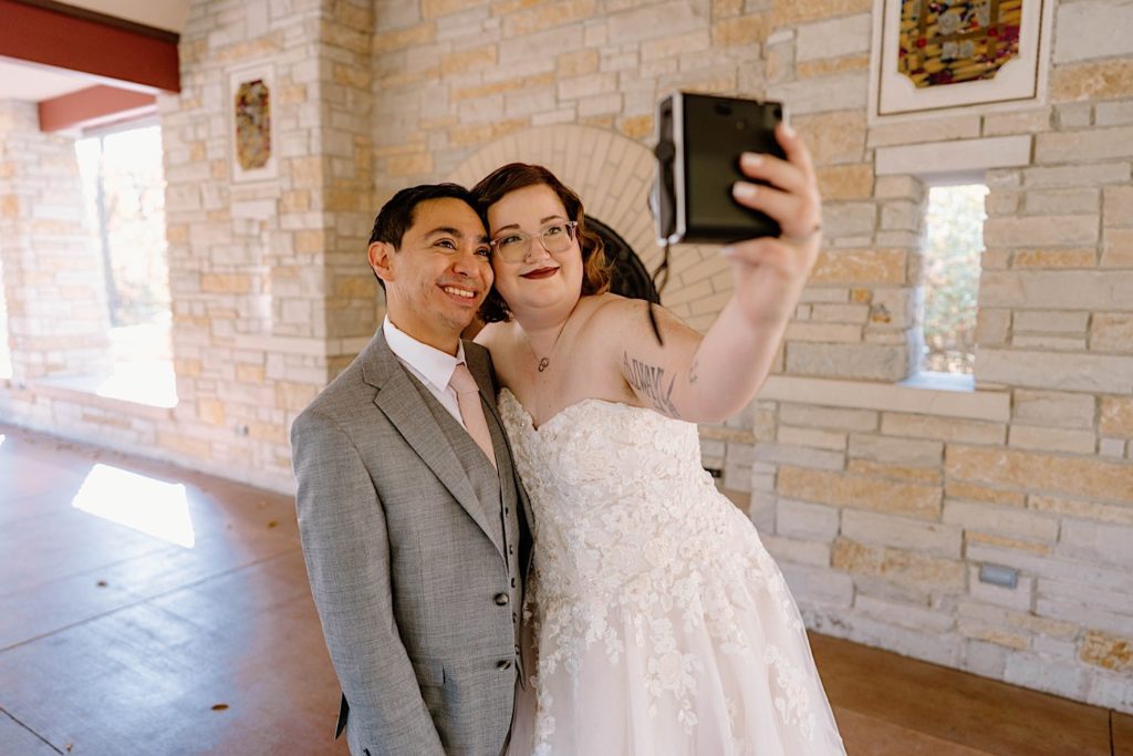 A bride and groom share take a selfie under the pavilion at the Grove Redfield Estate