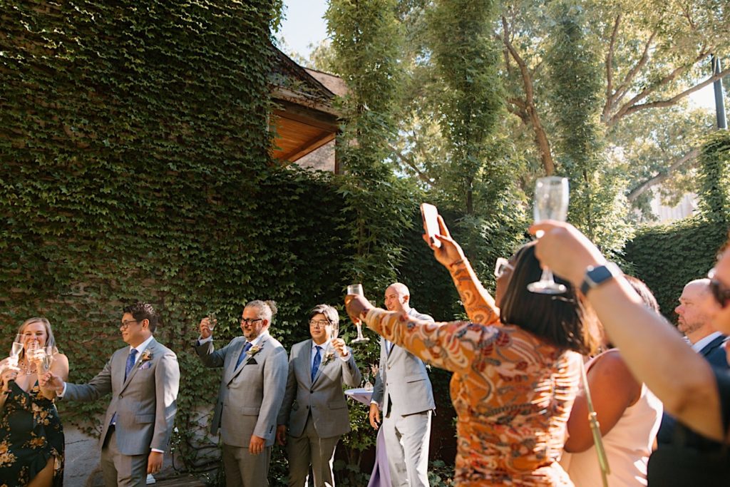 Guests toast the bride and groom outside their wedding reception.