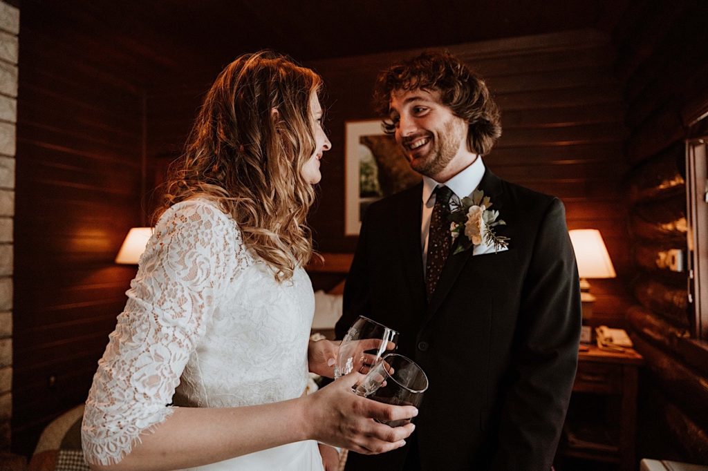 A bride and groom look at one another smiling at each other in their cabin at Starved Rock.