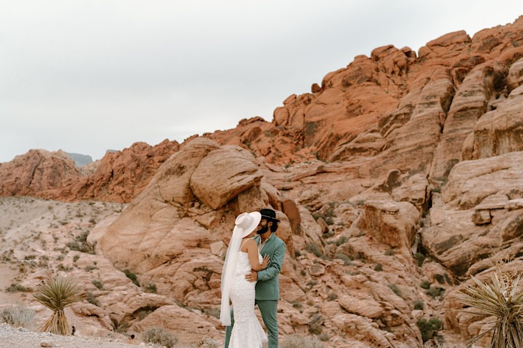 A bride and groom stand together during their elopement ceremony in Moab Utah