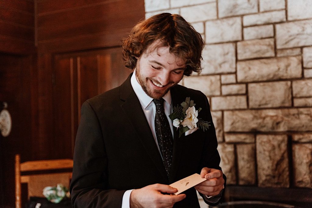 A groom opens a card from his bride the morning of their elopement at Starved Rock National Park