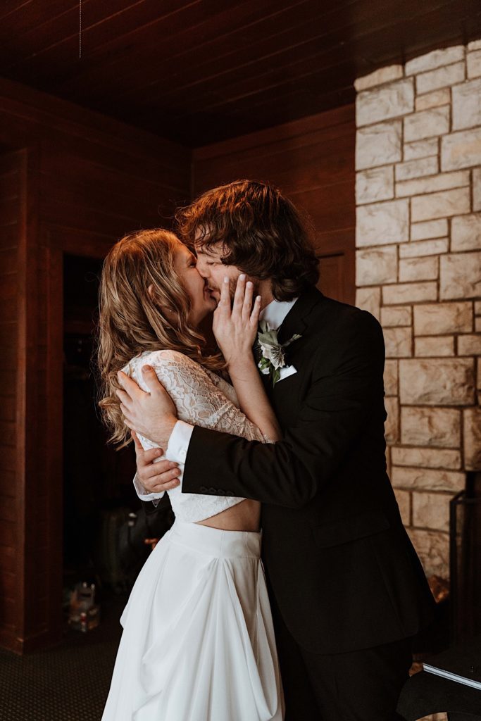 A bride and groom kiss one another lovingly after exchanging gifts at their wedding in their cabin at Starved Rock National Park