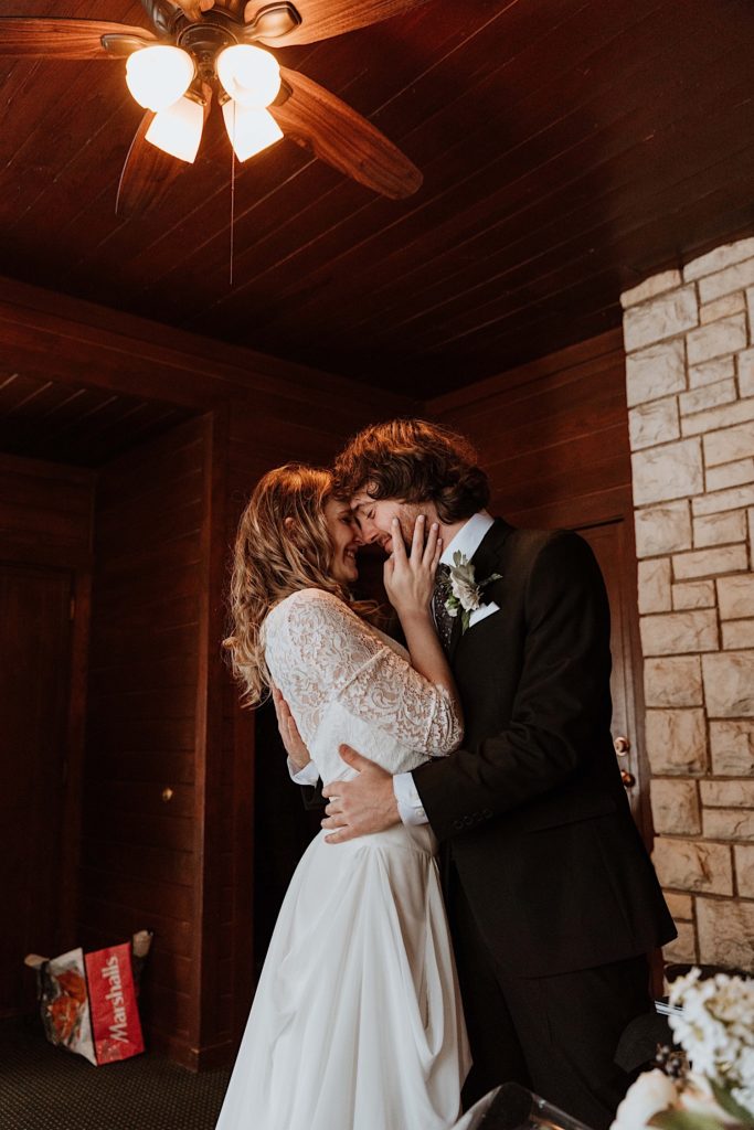 A bride and groom kiss one another lovingly after exchanging gifts at their wedding in their cabin at Starved Rock National Park