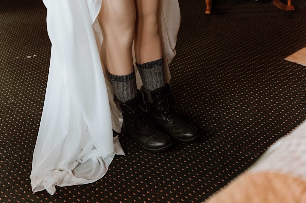 A bride puts on her snow boots before going out to take wedding portraits at Starved Rock National Park