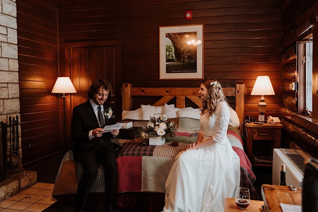 A bride and groom sit reading letters to one another while reading letters from family and friends before they elope at Starved Rock National Park