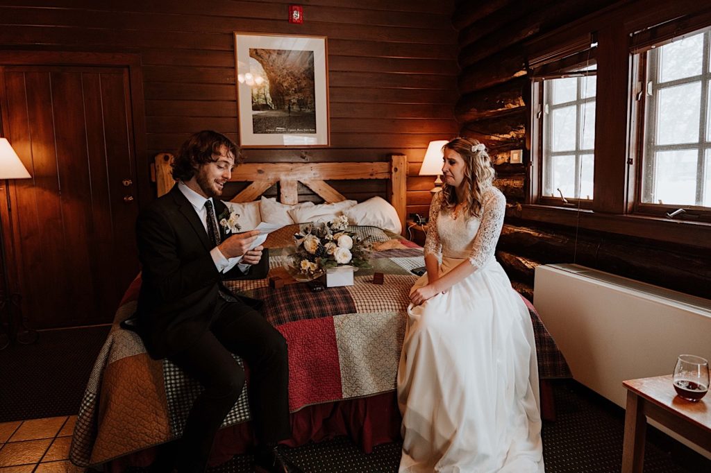A bride and groom sit reading letters to one another while reading letters from family and friends before they elope at Starved Rock National Park