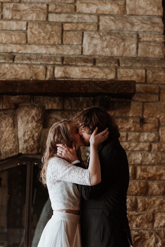 A bride and groom kiss during their wedding ceremony at a cabin in Starved Rock National Park