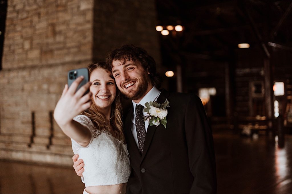 A bride and groom facetime their family members during their elopement at Starved Rock National Park.