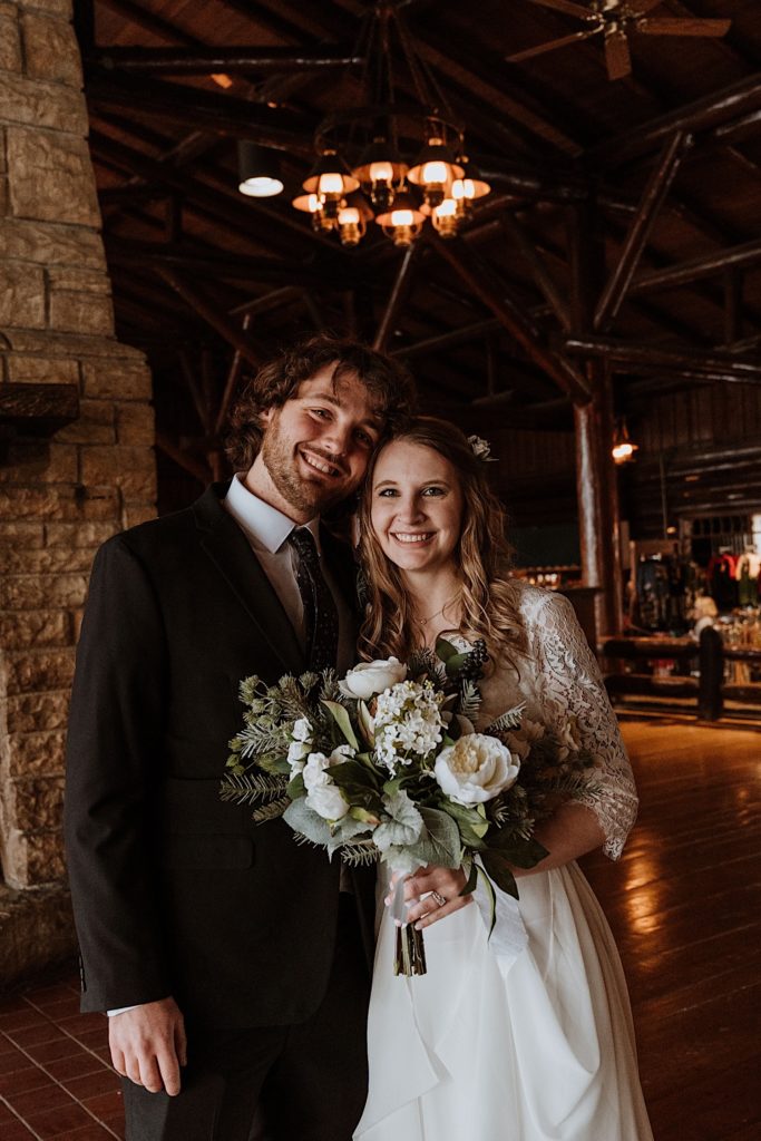 A bride and groom smile at the camera after their wedding ceremony at a cabin in Starved rock National Park