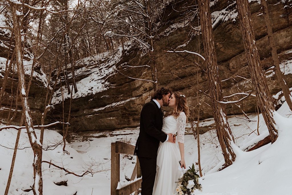 A bride and groom kiss overlooking a cliff at Starved Rock National Park.