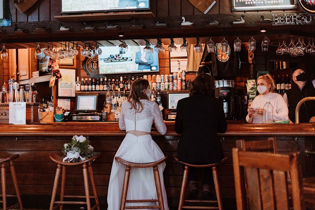A bride and groom share a drink at the bar at their cabin at Starved Rock National Park.