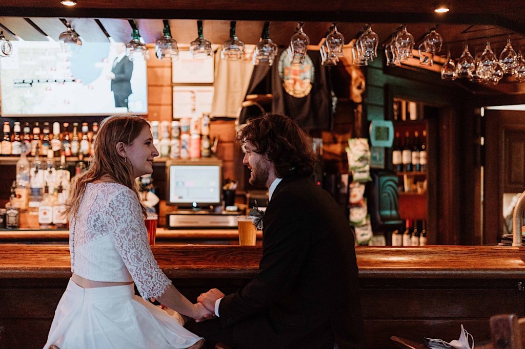 A bride and groom share a drink at the bar at their cabin at Starved Rock National Park.