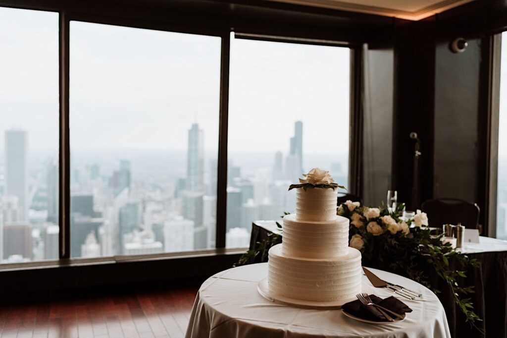 A wedding cake with white roses on the 95th Signature Room in Chicago
