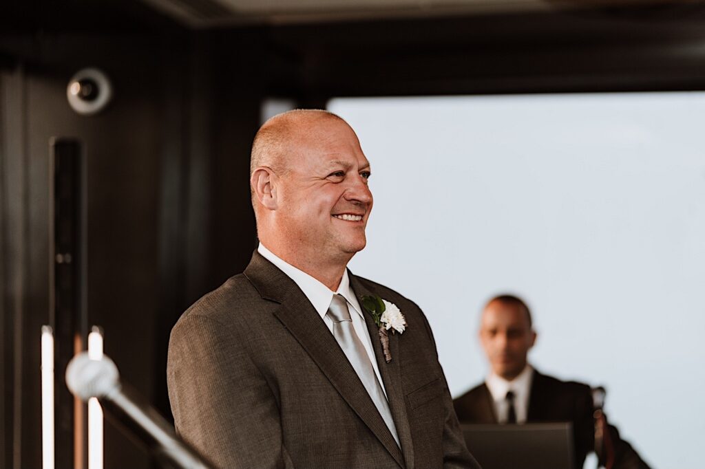 A groom stands during his ceremony waiting for his bride during his ceremony at the Signature Room on the 95th floor in Chicago.