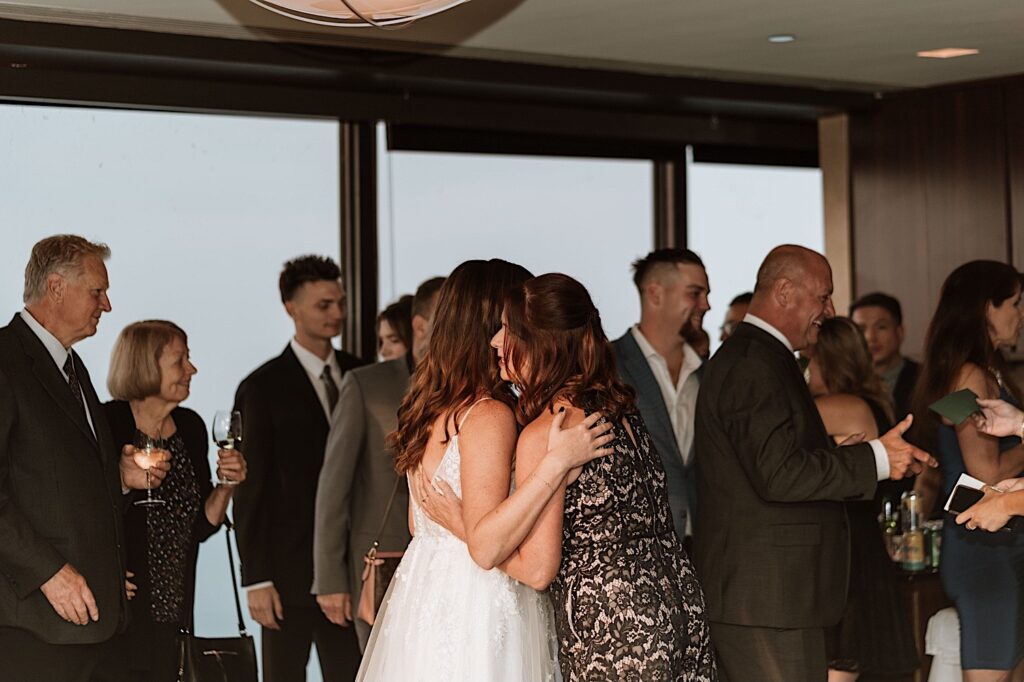 A bride hugs one of her guest following their wedding ceremony at their Chicago wedding venue.