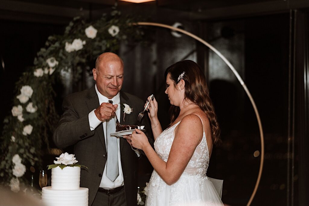 A bride and groom feed each other cake during their wedding reception at their Chicago wedding.