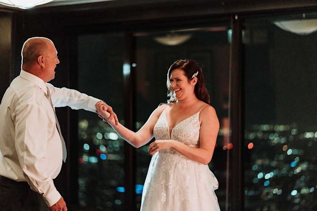 A bride and groom have their first dance at the Signature Room on the 95th floor.