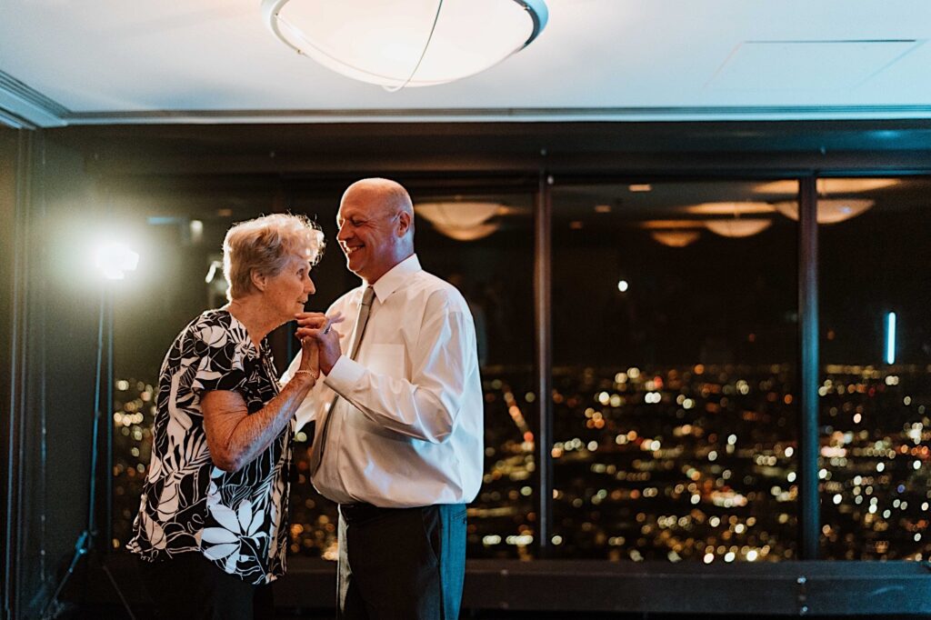 A groom and his mother share a dance during a wedding at the Signature Room on the 95th floor.