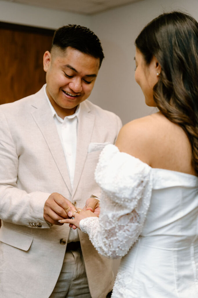 groom putting ring on bride's finger, chicago city hall elopement
