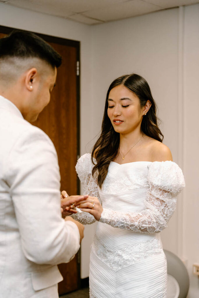 bride putting ring on groom's finger, chicago city hall elopement