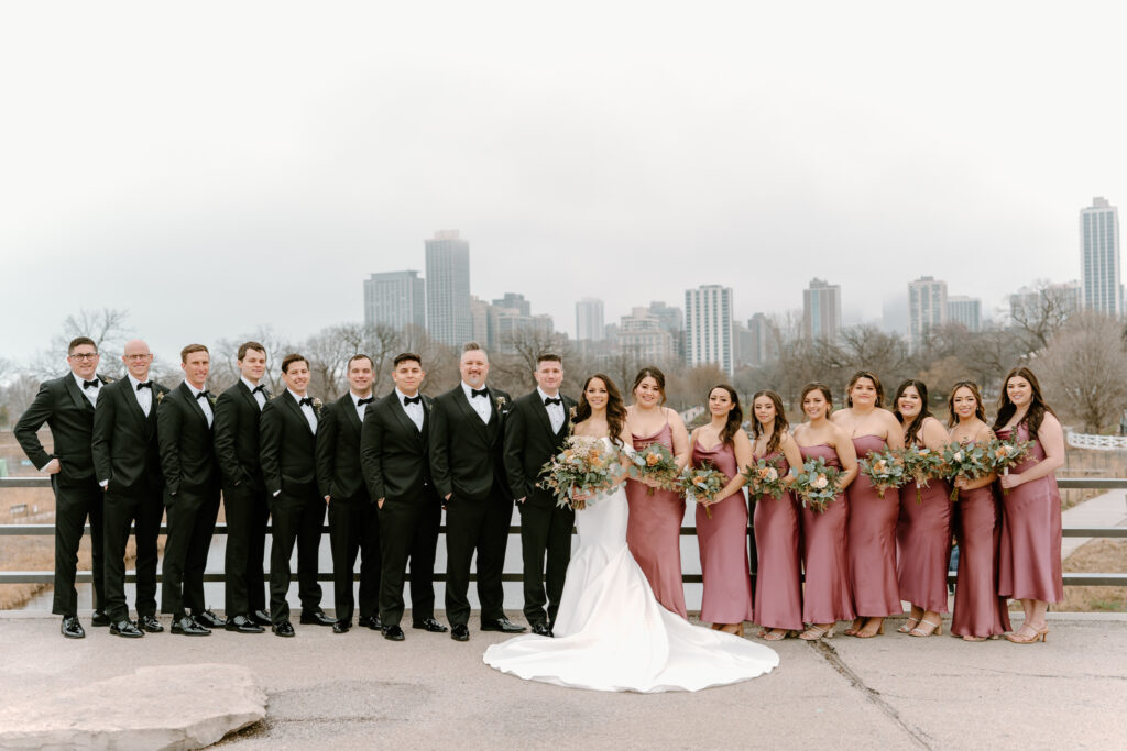 wedding party looking at the camera with the Chicago skyline behind them