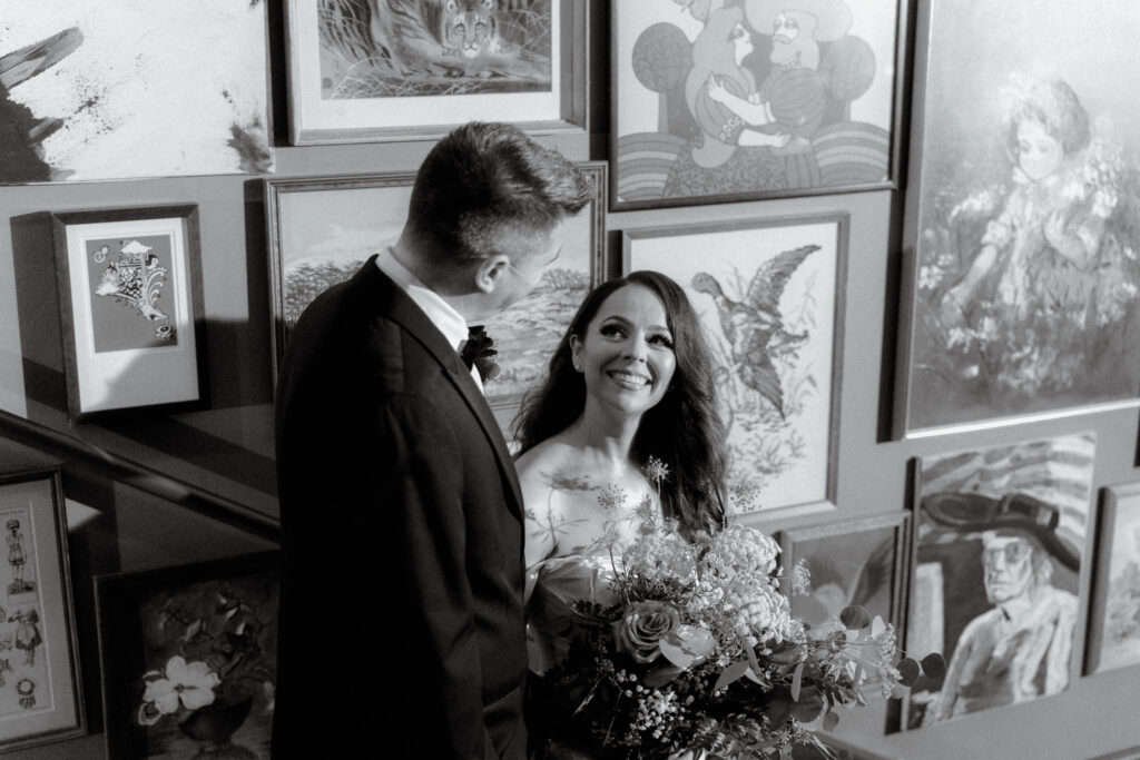 black and white photo of the bride looking up to her groom