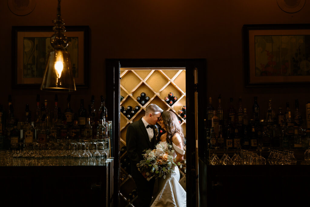 newlyweds kissing behind the bar