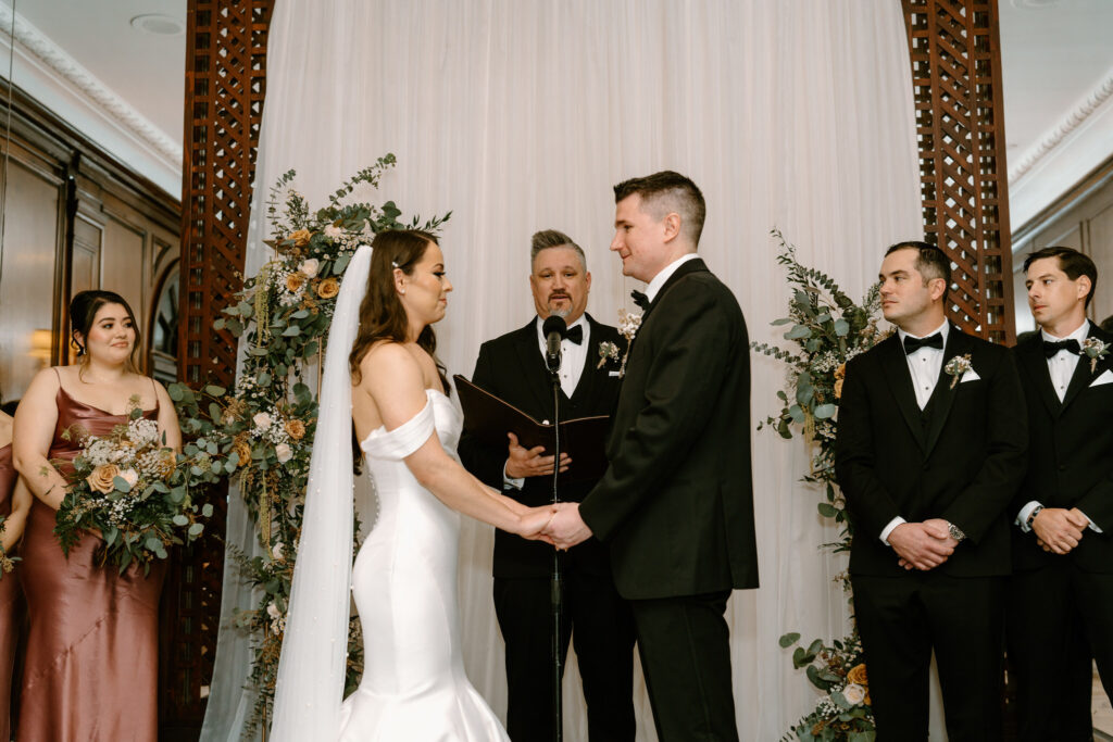 photo of bride and groom holding hands in front of the altar