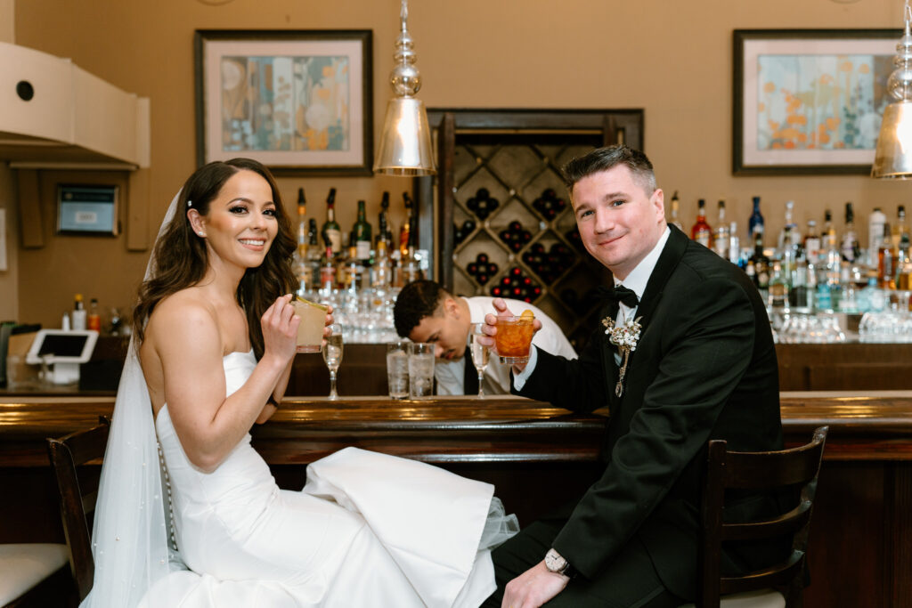 newlyweds sitting and having drinks at the bar