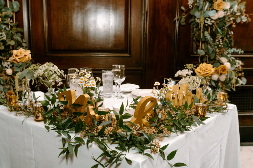 sweetheart table with yellow florals and greenery with yellow wooden Mr and Mrs letters